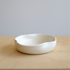 a white bowl sitting on top of a wooden table