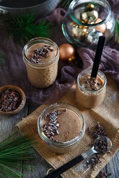 two jars filled with chocolate and nuts on top of a table next to christmas decorations