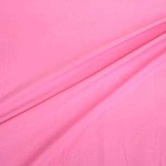 a pink sheet that is laying on top of a bed