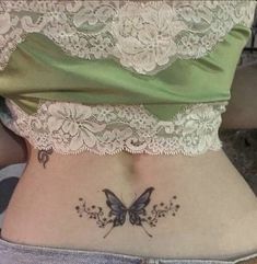 a woman with a butterfly tattoo on her lower back and the bottom part of her stomach