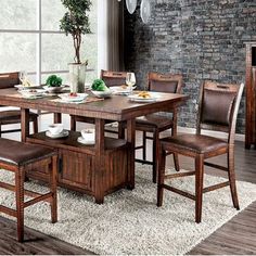 a dining room table and chairs in front of a brick wall with a potted plant