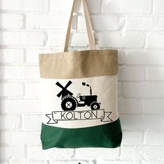 a tote bag hanging from the side of a brick wall with an image of a tractor and windmill on it