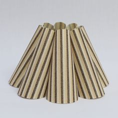 three striped lampshades on a white background, one with black and tan stripes