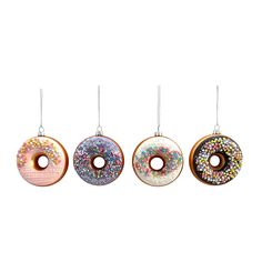 three donuts hanging from strings on a white background, one with sprinkles