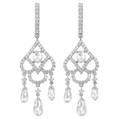 Embrace the timeless elegance of yesteryears with these stunning antique dangle earrings, meticulously crafted in lustrous 18 karat white gold. At the heart of each earring lies a shimmering rose cut diamond, weighing a collective 0.2 carats. Known for its vintage charm and romantic facets, the rose cut diamond gracefully anchors the design. Suspended beneath, a trio of dazzling briolette diamonds dances with every movement, their combined weight totaling 2.41 carats. Encircling the rose cut and accenting the length of the earring are glittering white round diamonds, adding an additional sparkle of 0.76 carats. Specifications: Metal: 18 Karat White Gold Central Diamonds: 2 Rose Cut, Totaling 0.2 carats Dangling Diamonds: 6 Briolette-cut, Totaling 2.41 carats Accents: White Round Diamonds, Luxury Exquisite Bridal Earrings With Rose Cut Diamonds, Luxury White Gold Wedding Jewelry With Rose Cut Diamonds, Luxury Briolette Diamond Wedding Earrings, Luxury Diamond White Jewelry With Rose Cut Diamonds, Briolette Diamond, Diamond Dangle Earrings, Vintage Rose, Belle Epoque, Rose Cut Diamond