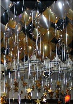 balloons and streamers are hanging from the ceiling in an indoor event space with stars on them