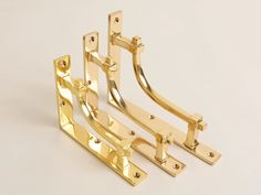 three golden metal brackets on a white background