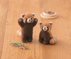 two small stuffed animals sitting on top of a wooden floor next to each other,