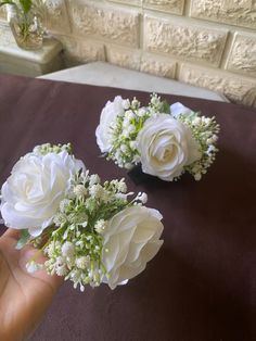 two white flowers are sitting on a table