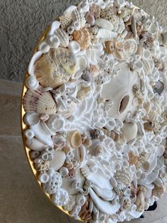 a cake decorated with sea shells and seashells on a gold rimmed plate