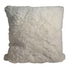 a white pillow with fluffy fur on the front and back of it's sides