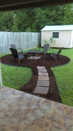 a patio with chairs and a fire pit in the back yard, next to a fence