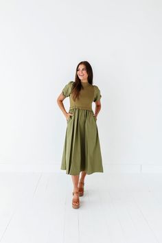 Features Mock neck Short puff sleeves with elastic Ribbed bodice Elastic waist Olive color Pockets 60% Cotton, 40% Polyester; Contrast: 52% Viscose, 26% Polyester, 22% Nylon Size + Fit Small 0-4, Medium 4-8, Large 8-12, X-Large 14-16, 1X 16-18, 2X 20-22, 3X 24-26 Kristin is 5'4", a size 1 and is wearing a Small Jaycie is 5'6" a size 18 and is wearing a 2X Runs true to size. Measurements taken while laying flat and then doubled. They do no account for stretch. Size Bra Band Length Small 34" 46" M Stretch Puff Sleeve Dress With Short Sleeves For Summer, Spring Dresses With Elastic Shoulders And Stretch, Spring Dresses With Stretch Elastic Shoulders, Spring Puff Sleeve Dress With Gathered Waist, Green Puff Sleeve Dress With Elastic Sleeves, Green Fitted Midi Dress With Elastic Sleeves, Fitted Green Midi Dress With Elastic Sleeves, Green Spring Dresses With Elastic Shoulders, Fitted Solid Color Dress With Elastic Waistband