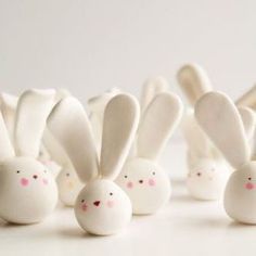 some white chocolate bunnies with pink noses and ears are lined up in a row