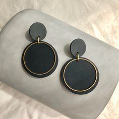 Elegant and light circular earrings in black and golden brass hoop. These handmade earrings are a perfect combination of modern style and minimalist geometric design. With clean lines and symmetrical shapes, these earrings have a contemporary look that fits perfectly for any occasion. In addition, their lightweight makes them comfortable to wear all day long. These modern earrings will be an ideal addition to any occasion. These earrings are unique and one-of-a-kind. They are carefully handmade Modern Black Round Hoop Earrings, Modern Black Hoop Earrings, Minimalist Black Round Hoop Earrings, Minimalist Black Earrings For Everyday, Modern Black Geometric Earrings, Black Minimalist Everyday Earrings, Modern Everyday Circular Earrings, Modern Black Hoop Earrings For Everyday, Minimalist Black Circular Jewelry