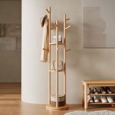 a wooden shoe rack with shoes on it next to a white wall and a gray rug