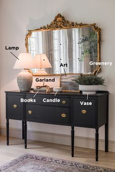 a black dresser with a mirror and lamp on top