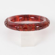 This is part of Chairish’s Costume Jewelry assortment.  Stunning red tea amber marble Bakelite bracelet bangle. Chunky rounded domed shape with a deep floral carving all around. Intense orange-red color with lots of cloudy swirling and translucency. Measurements: Inside across is 2.50 in diameter (6.4 cm) - outside across is 3.63 in diameter (9.2 cm) - width is 0.57 in wide (1.4 cm) - the wall is 0.57 in thick (1.4 cm).  Please see the measurements noted above in the description for the best app Luxury Red Bangle, Vintage Red Resin Jewelry, Elegant Bakelite Bangle As Gift, Elegant Bakelite Bangle As A Gift, Adjustable Carved Round Bracelets, Luxury Carved Bangle Bracelets, Luxury Carved Bangle Bracelet, Adjustable Carved Bracelets, Formal Brown Round Bangle