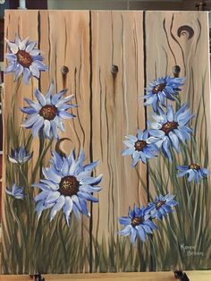 a painting of blue flowers on a wooden board