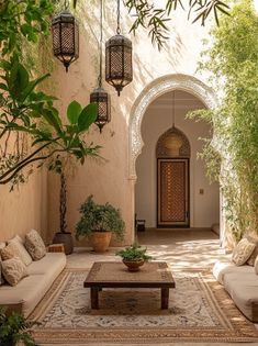 an outdoor living area with couches, tables and potted plants