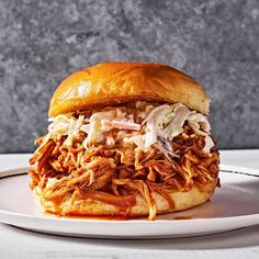 a pulled pork sandwich on a white plate