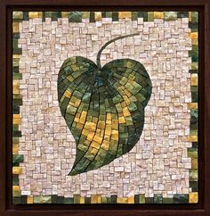 a piece of art that looks like a leaf with yellow and green tiles on it