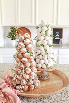 two christmas trees made out of donuts on a wooden platter with pink and white striped napkins