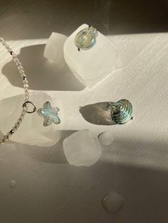 Handcrafted with care, this labradorite choker is a perfect blend of elegance and beachy vibes. Featuring delicate glass seashell and starfish pendants, each piece is uniquely designed to complement any look. Made with high-quality materials, it's the perfect accessory for those who love the ocean and appreciate artisan craftsmanship. Shell-shaped Ocean-inspired Jewelry With Starfish Charm, Ocean-inspired Jewelry With Starfish Charm And Shell Shape, Ocean-inspired Jewelry With Star Charm, Ocean-inspired Shell Jewelry With Starfish Charm, Handmade Starfish Shell Jewelry, Handmade Starfish Shell Necklace, Ocean-inspired Style, Handmade Starfish Shell Necklace In Ocean Style, Handmade Shell Starfish Jewelry, Handmade Starfish Shaped Shell Jewelry