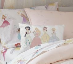 a bed topped with lots of pillows covered in princesses