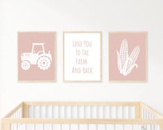 three pink and white nursery prints on the wall above a baby's crib