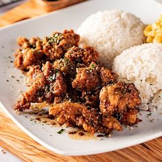 a white plate topped with rice and meat