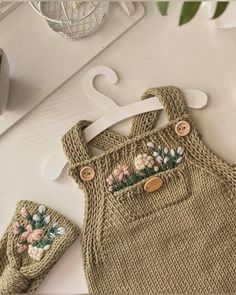 a baby's knitted outfit and booties sitting on top of a table