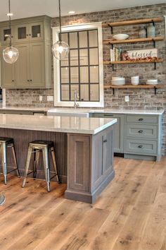 a large kitchen with an island and two stools in front of the counter top