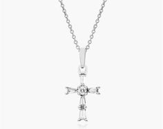 14K White Gold Moderne Cross Diamond Necklace. This classic cross necklace is a beautiful display of faith. Set in stunning 14K gold, tapered baguette-cut diamonds line the design with a brilliant round diamond at the center. The pendant hangs from an 18-inch cable chain with an extra jump ring at 16 inches for versatility and secures with a lobster clasp. Classic Diamond Cross Necklace For Formal Occasions, Elegant Crucifix Diamond Necklace For Anniversary, Elegant Formal Crucifix Diamond Necklace, Classic Diamond Cut Cross Necklace For Formal Occasions, Classic Formal Cross Necklace With Diamond Cut, Formal Crucifix Necklace With Brilliant Cut, Formal White Gold Crucifix Diamond Necklace, Formal Brilliant Cut Crucifix Necklace, Elegant Cross Shaped Jewelry With Baguette Diamonds