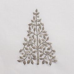 an embroidered christmas tree is shown on a white background with silver trimmings and sequins