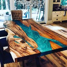 a dining room table made out of wood with blue paint on the top and bottom