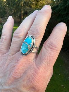 Swimmingly beautiful Sea Sediment Jasper stone that brings to mind Caribbean blue seas!  This stone is so pretty - the blue has hints of white and a lovely gold matrix crosses the center. Set in fine and sterling silver, the stone is framed with a pretty scalloped bezel and a simple shadow box with wire and bead border.   Definitely one of our favorites!  The ring has a nice weight and a very comfortable split shank.  Ring is US Sized 6.75.  The face of the setting is approximately 1/2 inch wide by 1 inch length.   We are a small family business.  All of our jewelry is handmade by us with fine and sterling silver and beautiful stones.  We source the majority of our turquoise cabochons from small business lapidary artists located in the United States. Find us on Instagram: @RimmerCreations Turquoise Gemstone Moonstone Ring, Oval Turquoise Inlay Rings, Oval Turquoise Rings With Inlay, Blue Moonstone Healing Ring, Blue Untreated Southwestern Rings, Unique Turquoise Moonstone Ring, Unique Blue Cabochon Moonstone Ring, Blue Turquoise Ring With Large Stone For Anniversary, Unique Blue Moonstone Cabochon Ring