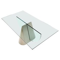 a glass table with a metal base and curved edges on the top, in front of a white background