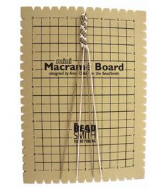 a pair of knitting needles sitting on top of a piece of paper with the words macrame board written across it