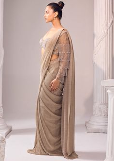 a woman in a beige sari with sheer sleeves