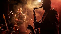 two men are playing instruments on stage