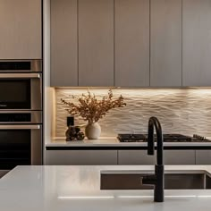 a modern kitchen with stainless steel appliances and white countertops