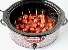 a crock pot filled with meatballs and skewered on toothpicks