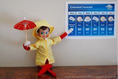 an elf is standing in front of a weather chart with an umbrella on his head