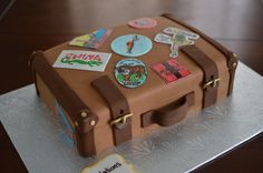 a cake shaped like a suitcase with stickers on it