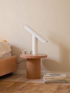 a lamp that is sitting on top of a table next to a bed and some books