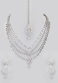 Featuring a layered faux diamond necklace with a white finish enhanced with tiered diamond pendants. Perfectly matched with earrings and a delicate mang tikka. Perfect for for modern bride for wedding and festive occasions. Composition : Mixed Metal Care: Avoid exposure to water and perfume. Store in dry plastic or fabric pouch. To clean, use a soft cloth to wipe the jewellery. Delivery : 6-8 weeks as the product is hand crafted. For more information and sizes please contact fabiliciousfashion@g Mang Tikka, Indian Theme, Fabric Pouch, Diamond Pendants, Perfume Store, Indian Wedding Wear, Diamond Necklace Set, Traditional Indian, Modern Bride