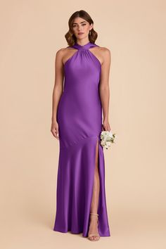 a woman wearing a purple dress with high slit