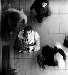 a black and white photo of people on the floor with one person holding a camera