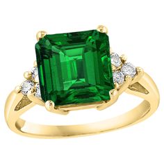 an emerald and diamond ring set in yellow gold